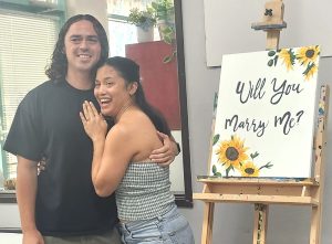 Couple celebrating a surprise marriage proposal at Burst of Butterflies Peoria art studio