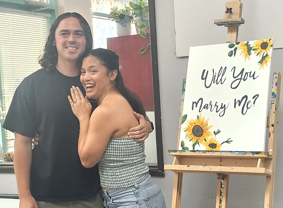 Couple celebrating a surprise marriage proposal at Burst of Butterflies Peoria art studio